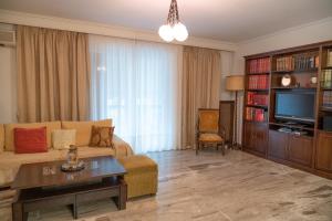 sala de estar con sofá y TV en Aiolos Apartment en Athens