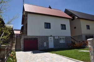 a large white house with a red garage at Apartment VUK in Žabljak