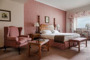 - une chambre avec un lit, une chaise et une table dans l'établissement Llao Llao Resort, Golf-Spa, à San Carlos de Bariloche