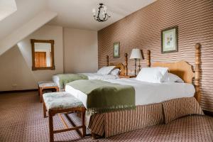 une chambre d'hôtel avec deux lits et deux chaises dans l'établissement Llao Llao Resort, Golf-Spa, à San Carlos de Bariloche