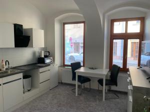 a kitchen with a table and two chairs and a table at Apartmány Žižkova in Česká Lípa