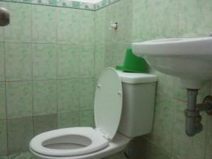 a bathroom with a white toilet and a sink at GV Hotel - Camiguin in Mambajao