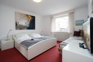 ein Schlafzimmer mit einem großen weißen Bett und einem TV in der Unterkunft Seepferdchen in Westerland