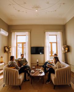 un grupo de personas sentadas en una sala de estar en Royal Collection Covilhã, en Covilhã