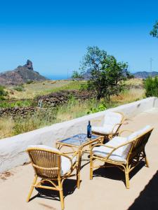 Dos sillas y una mesa con una botella. en Casa-Finca El Maipéz de Tejeda, en Las Palmas de Gran Canaria