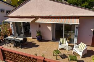 eine Terrasse mit einem Tisch, Stühlen und einem Tisch in der Unterkunft Apartment Axelle 50 METERS TO THE BEACH in Banjole