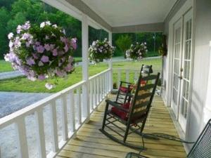 two rocking chairs sitting on a porch with flowers at Sweetpeas in Pigeon Forge