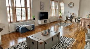 uma sala de estar com uma mesa e uma televisão em Penthouse, 2 Bedroom apartment em Great Yarmouth