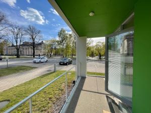 a green house with a balcony with a view of a street at Hostel Teopolis in Tampere