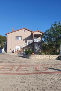 a large house with a stone driveway in front of it at Apartments Željka in Rab