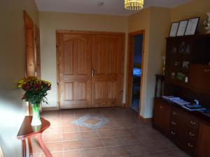 una habitación con una puerta y un jarrón de flores sobre una mesa en Manorview B&B, en Cookstown