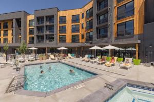 a pool at a hotel with people sitting in chairs at YOTELPAD Park City in Park City