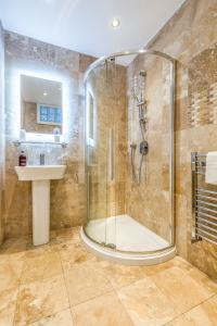 a bathroom with a shower and a sink at Ashbys Deluxe Studios & Spa hire in Portsmouth