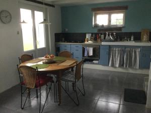 a kitchen with a wooden table and chairs in a room at Nuitées au calme de la campagne bourbonnaise in Paray-sous-Brailles