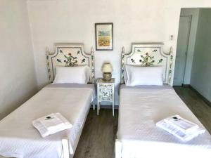 two twin beds in a room with a table at Vinha da Quinta in Sintra