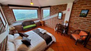 ein Schlafzimmer mit einem großen Bett in einem Zimmer mit Fenstern in der Unterkunft Balcon al Cotopaxi Hosteria in Sangolquí