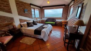a bedroom with a bed and a table and a window at Balcon al Cotopaxi Hosteria in Sangolquí