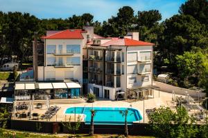 a large building with a swimming pool and a resort at Premantura Resort - Hotel & Restaurant in Premantura