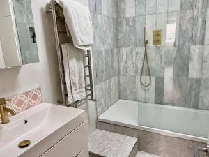 a bathroom with a tub and a sink and a shower at Thames Bankside River View City Apartment in London