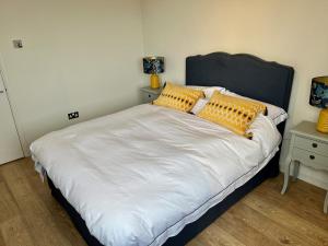 a bedroom with a large bed with yellow pillows at Thames Bankside River View City Apartment in London