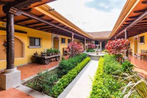 a courtyard of a house with a fountain and plants at Villa El Retiro Luxury Property in Alajuela City