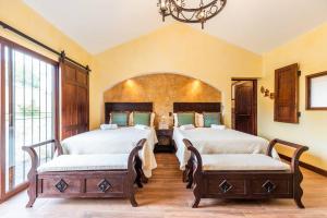 a bedroom with two beds and a chandelier at Villa El Retiro Luxury Property in Alajuela City
