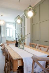 a dining room table with a white tablecloth and two lights at The Bishy by Chateau Anna, York city centre & free parking in York +39 photos