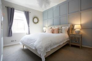 a bedroom with a large white bed with pink pillows at The Bishy by Chateau Anna, York city centre & free parking in York