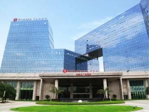 a large glass building in front of a building at Ramada Plaza Liuzhou Liudong in Liuzhou
