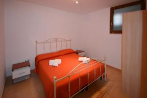 una camera con un letto arancione con due asciugamani di Dependance REVERSE a Carovigno