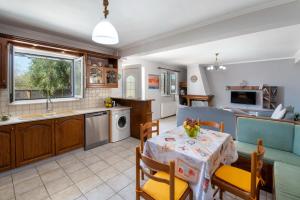 a kitchen and a living room with a table and chairs at Sterna House Paxos in Vlachopoulátika