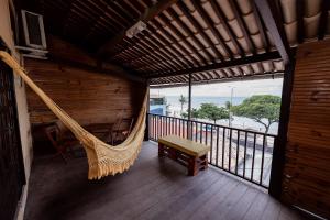 a hammock in a room with a view of the ocean at Pousada Terra do Sol Natal in Natal