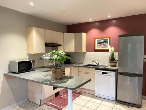 a kitchen with a counter with a microwave and a refrigerator at Les Mouettes in Escalles