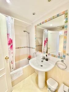 W łazience znajduje się umywalka, toaleta i lustro. w obiekcie Playa San Juan / Luxury Aparment w Alicante