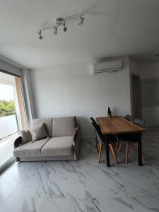 a living room with a couch and a table at Mierzeja Park 13 apartament 40m2 in Sztutowo