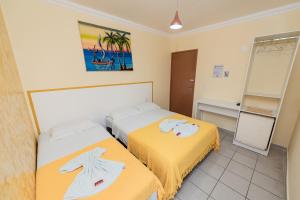Habitación de hotel con 2 camas y espejo en Pousada Terra do Sol Natal, en Natal