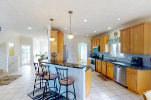 a kitchen with a island with bar stools at A Slice of Paradise in Virginia Beach