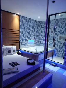 Habitación con cama y pared de cristal. en Vênus Inn Motel en Poá