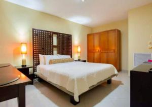 a bedroom with a large white bed and a desk at Apartamento en Oranjestad Aruba Zona de Cruceros in Oranjestad