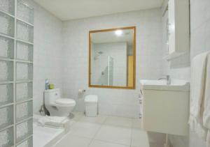 a bathroom with a toilet and a sink and a mirror at Apartamento en Oranjestad Aruba Zona de Cruceros in Oranjestad