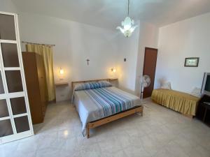 1 dormitorio con 1 cama y TV en Fiordaliso - Holiday Housing, en Lipari