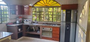 uma cozinha com um frigorífico de aço inoxidável e uma janela em Finca Las Mercedes en encantador entorno natural em El Triunfo