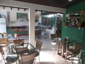 a room with chairs and tables and a kitchen at Pousada Ares do Sul in Penha