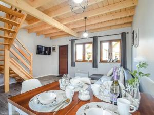 a dining room with a wooden table with white dishes at Seaside domki in Mielno