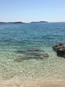 un gran cuerpo de agua con rocas. en Apartmani Silence, en Rogoznica