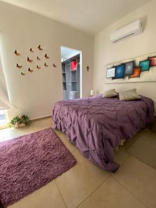ein Schlafzimmer mit einem Bett mit lila Bettwäsche und Vögeln an der Wand in der Unterkunft Casa de tus Sueños Dream Lagoons Veracruz in Veracruz