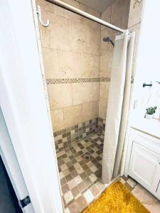uma casa de banho com um chuveiro e piso em azulejo em Pet Friendly! Private retreat in Nob Hill em Albuquerque