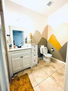 a bathroom with a toilet and a sink and a mirror at Pet Friendly! Private retreat in Nob Hill in Albuquerque