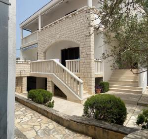 une maison avec un escalier sur son côté dans l'établissement Apartmani Silence, à Rogoznica