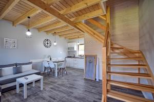 a living room with a staircase and a kitchen at Seaside domki in Mielno